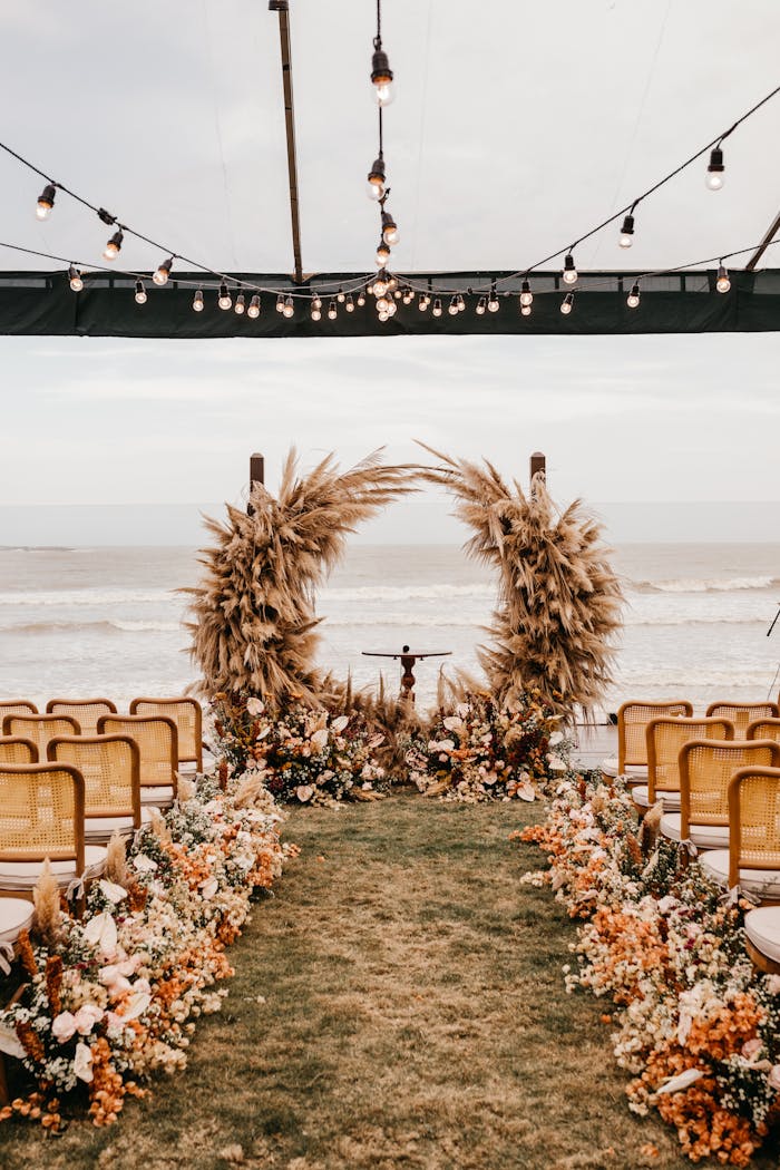 Beautiful beachfront wedding setup with floral arrangements and warm lighting.