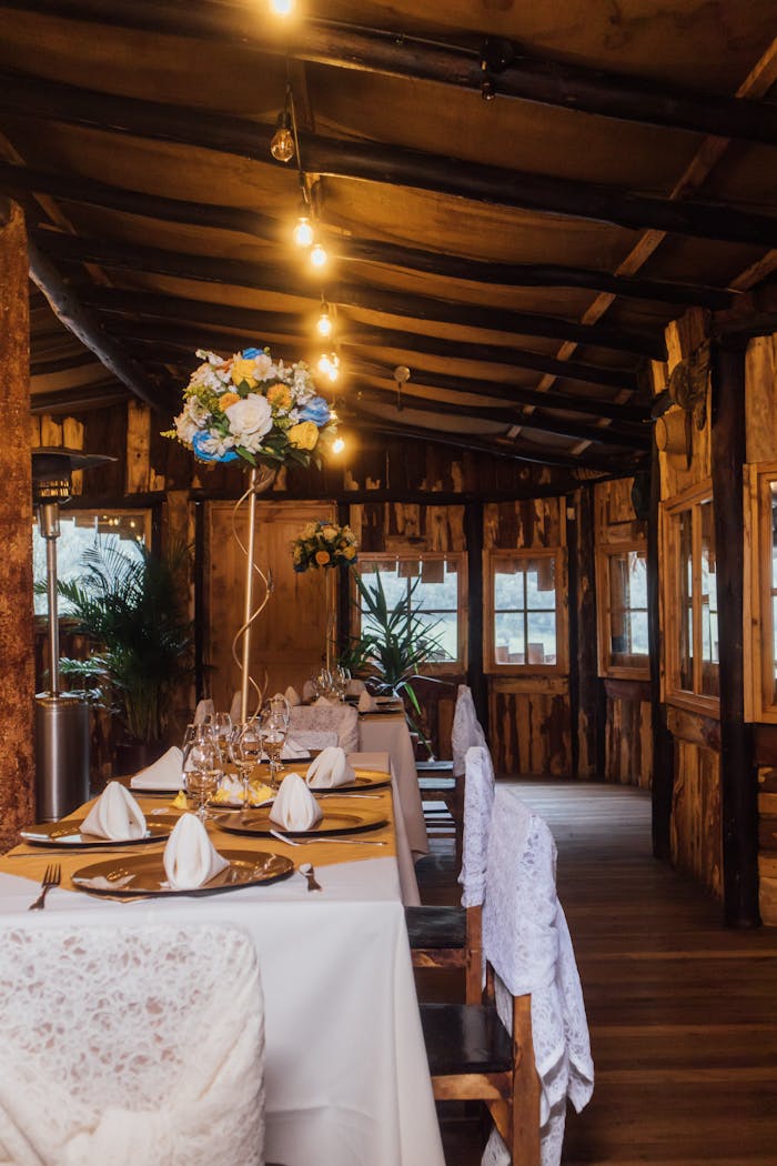 Rustic dining setup with floral decor in a wooden interior, Cuenca, Ecuador.
